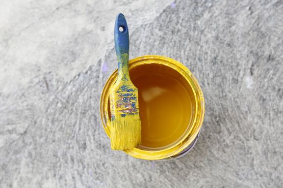 Brocha pintada de amarillo encima de bote